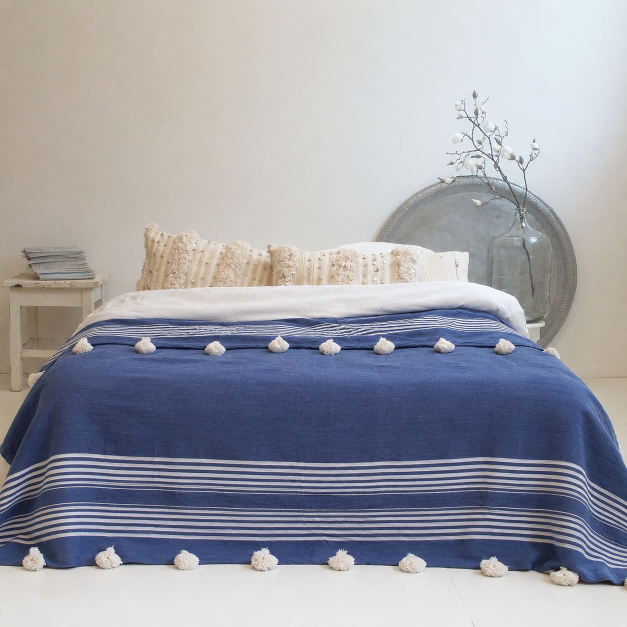 Manta Azul con lineas blancas con pompones blancos