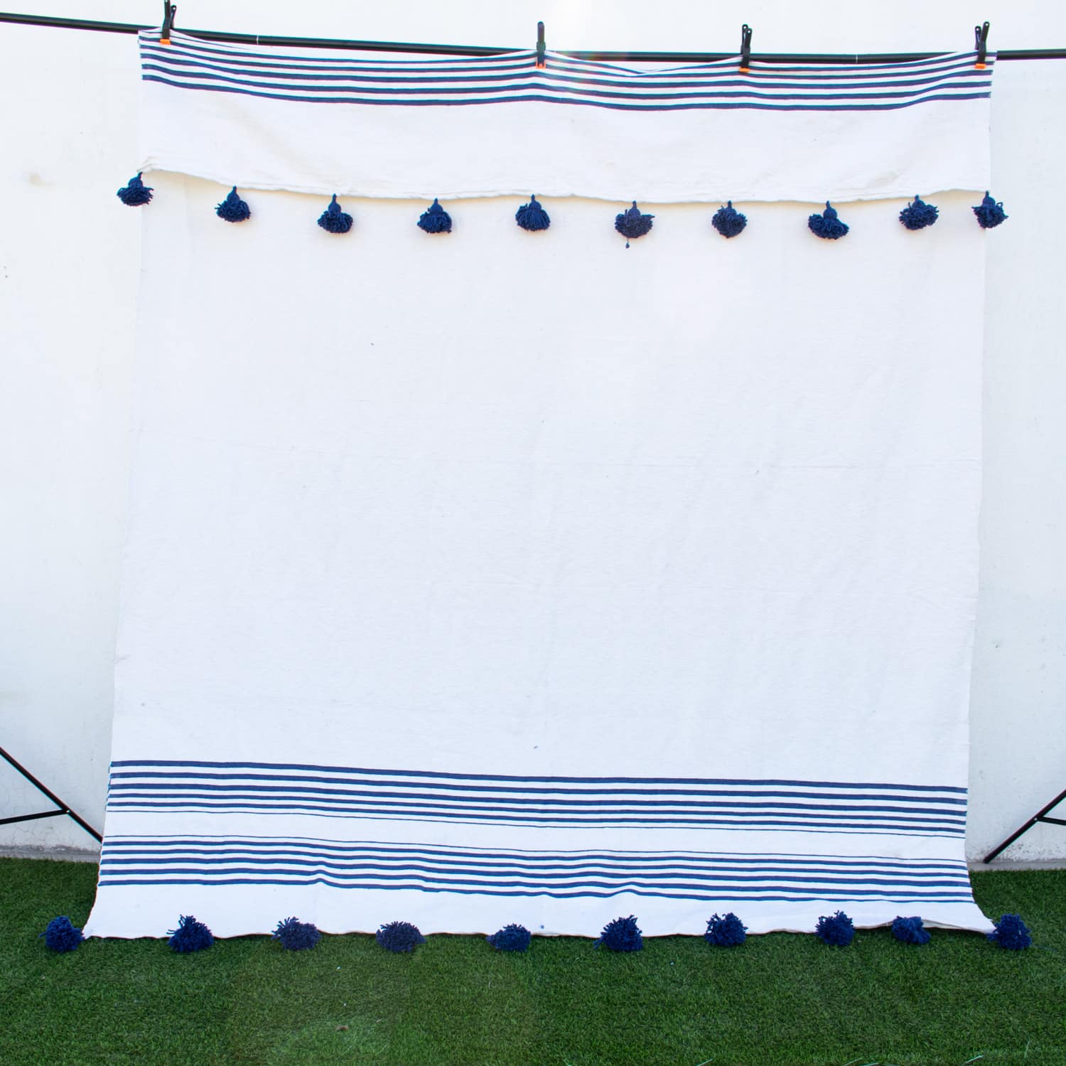 Manta Blanca con lineas azules y pompones azules
