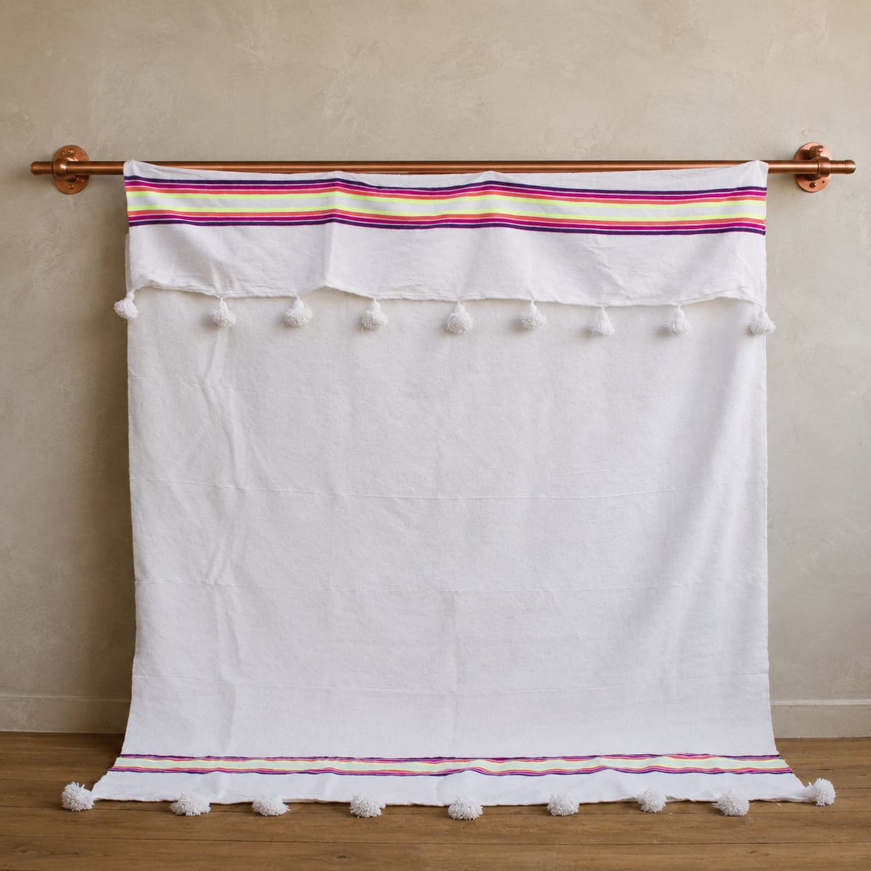 Manta Blanca con lineas de colores y pompones blancos