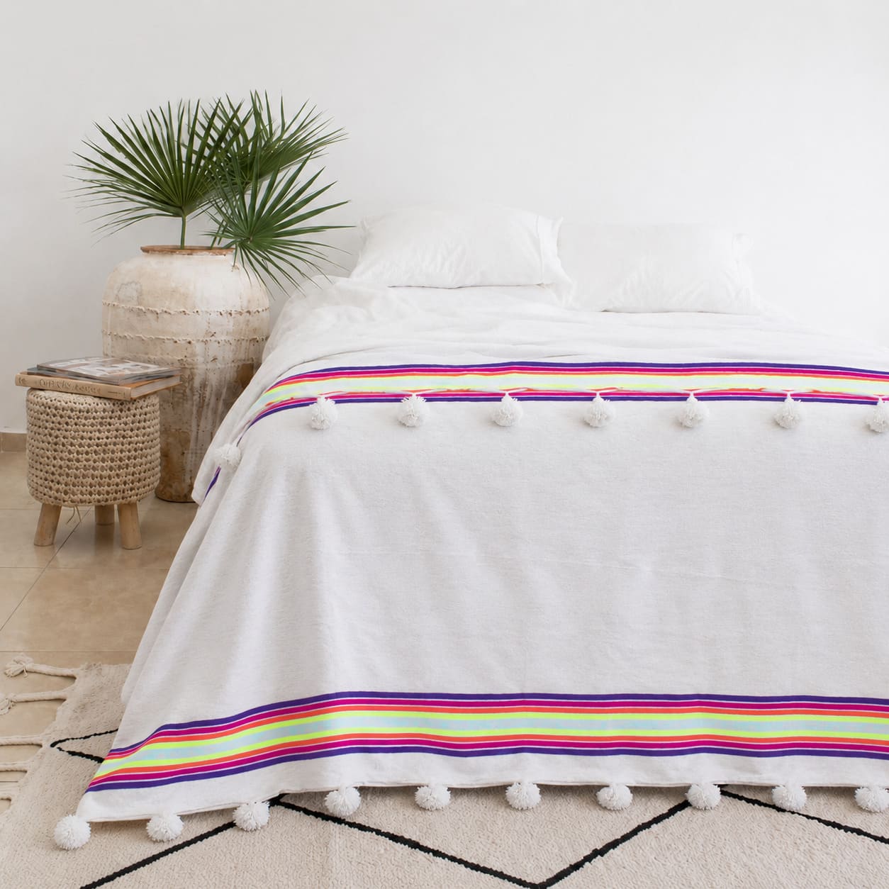 Manta Blanca con lineas de colores y pompones blancos